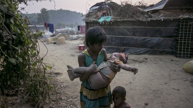 A girl carries a toddler in her arms in Kutapalong Rohingya refugee camp in Cox's Bazar, Bangladesh.  Photo: Getty Images